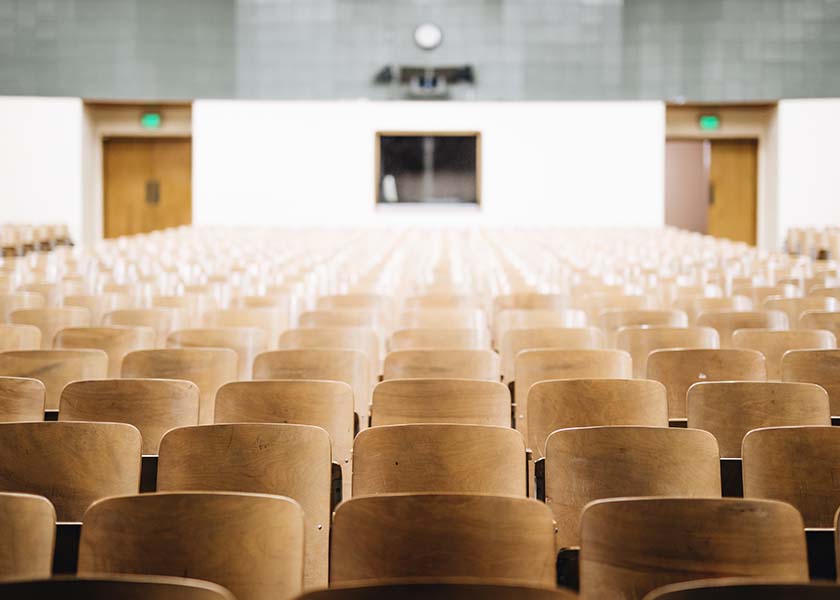 Imagen de una sala con muchas sillas. Puede parecer un salón de actos o de conferencias